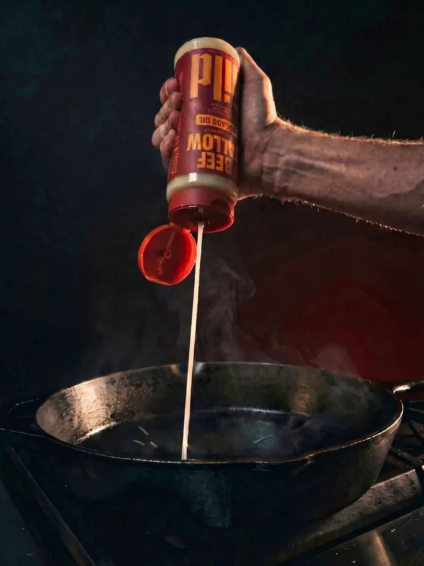 GILD Beef Tallow squeezed in a creamy ribbon into a hot cast-iron pan