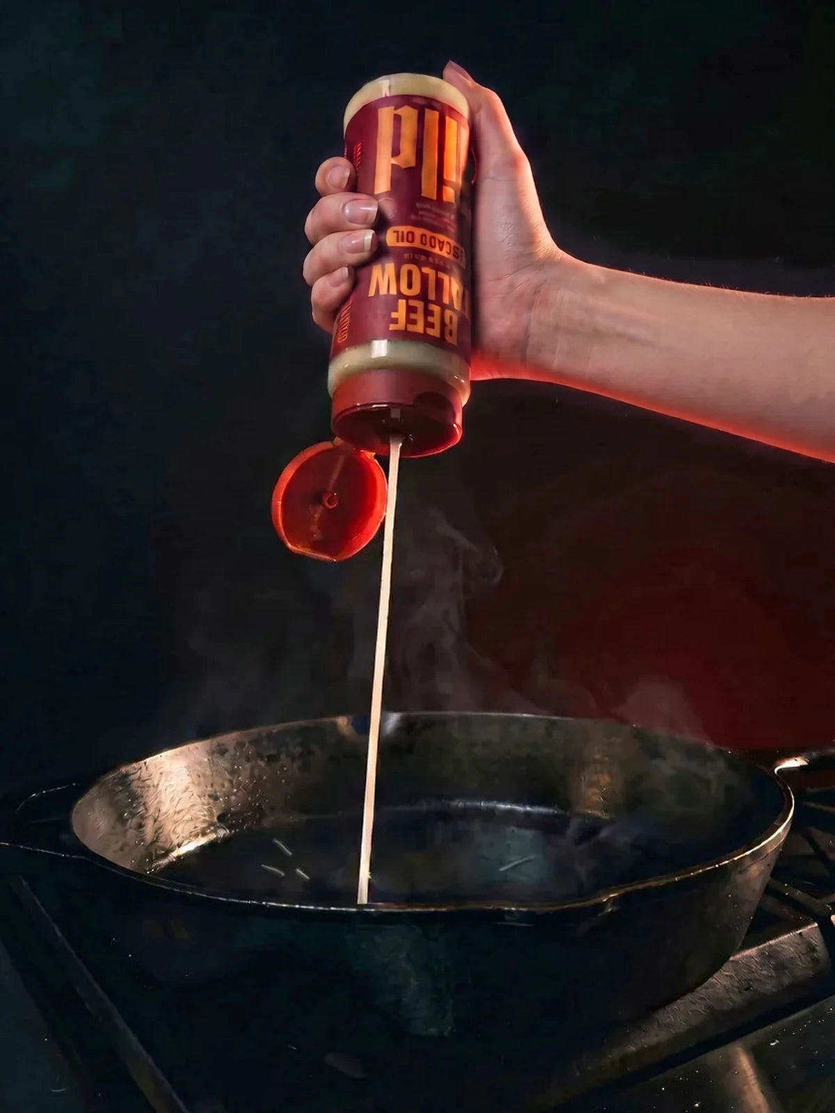 GILD Beef Tallow squeezed in a creamy ribbon into a hot cast-iron pan